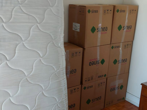 Colchón y cajas embaladas por Mudanzas Saenz, listos para ser transportados.